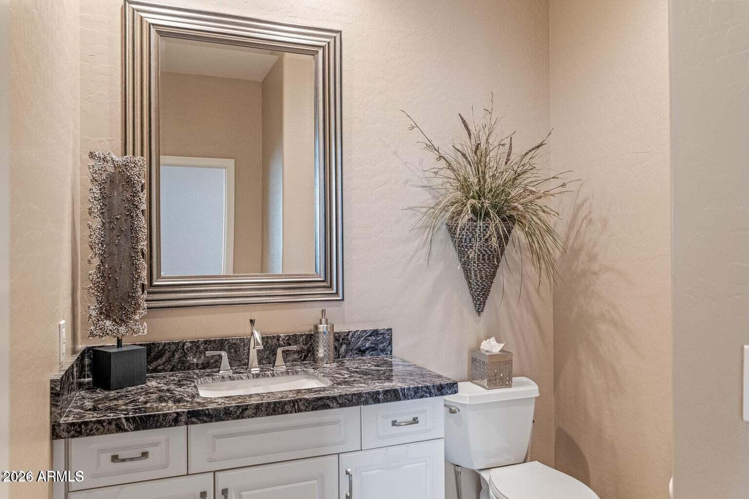 26601 North Aguila Road Rio Verde, AZ 85263 - Photo 16 of 45 a bathroom with a granite countertop sink a toilet and mirror