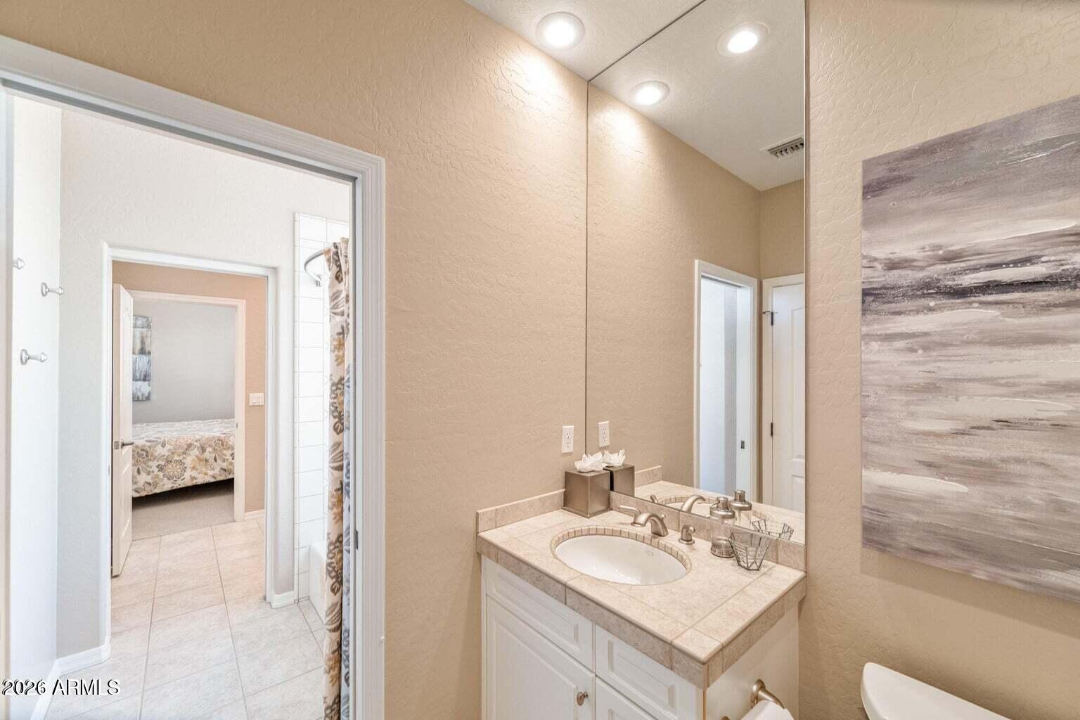 26601 North Aguila Road Rio Verde, AZ 85263 - Photo 27 of 45 a en suite bathroom with a sink and a mirror