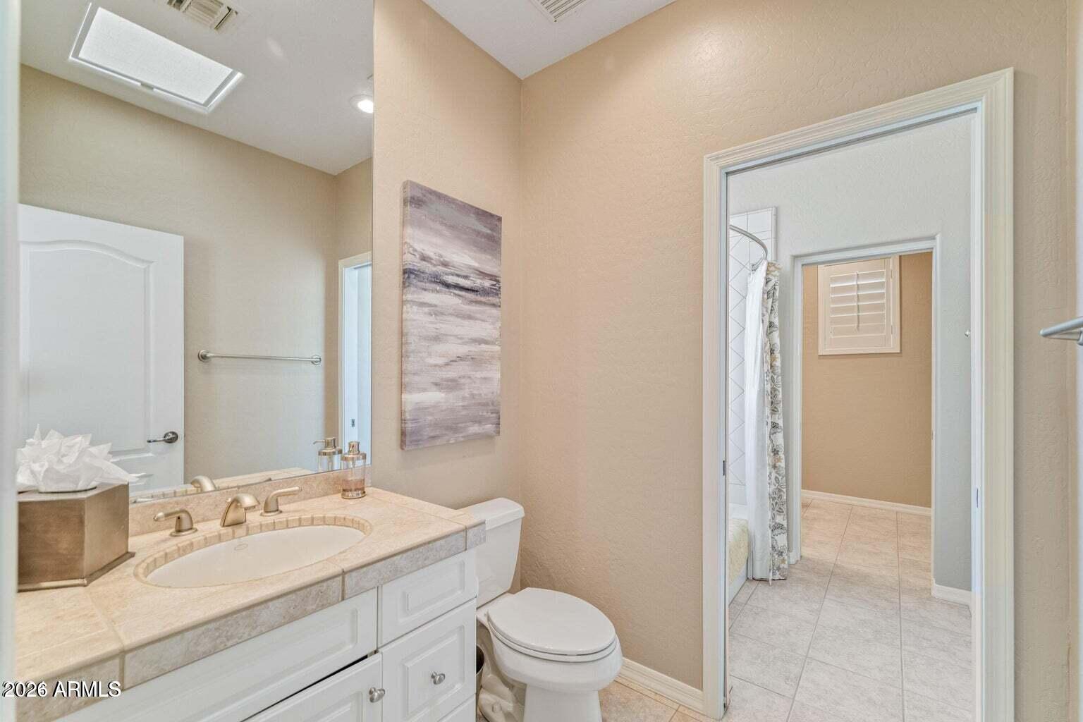 26601 North Aguila Road Rio Verde, AZ 85263 - Photo 28 of 45 a bathroom with a granite countertop sink a toilet and a mirror