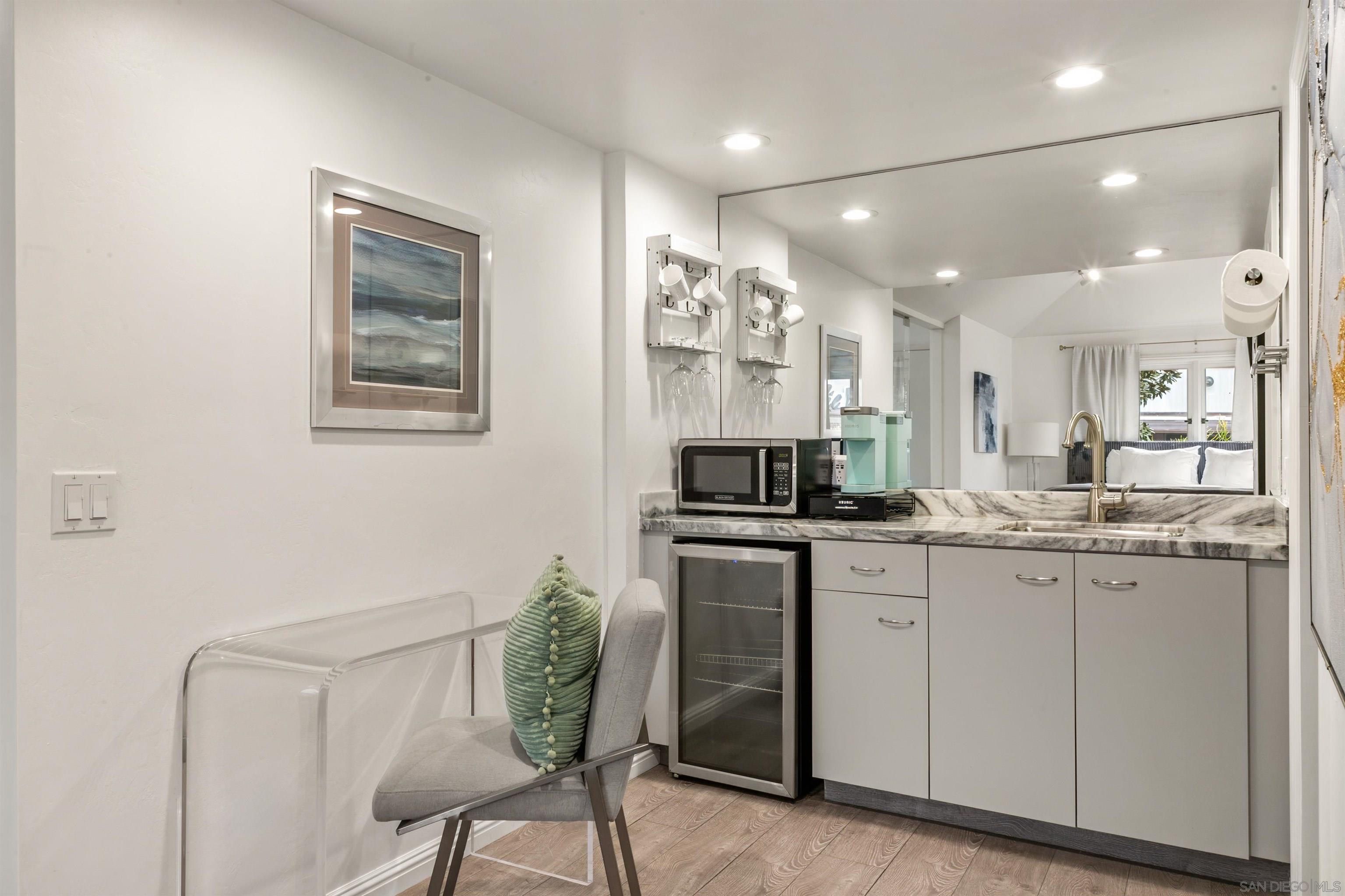 1264 Prospect Street La Jolla, CA 92037 - Photo 8 of 10 a kitchen with granite countertop white cabinets and chairs