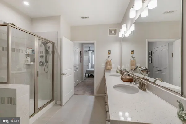 a bathroom with a bathtub shower sink and mirror
