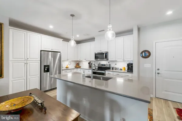 a kitchen with stainless steel appliances a refrigerator sink and microwave