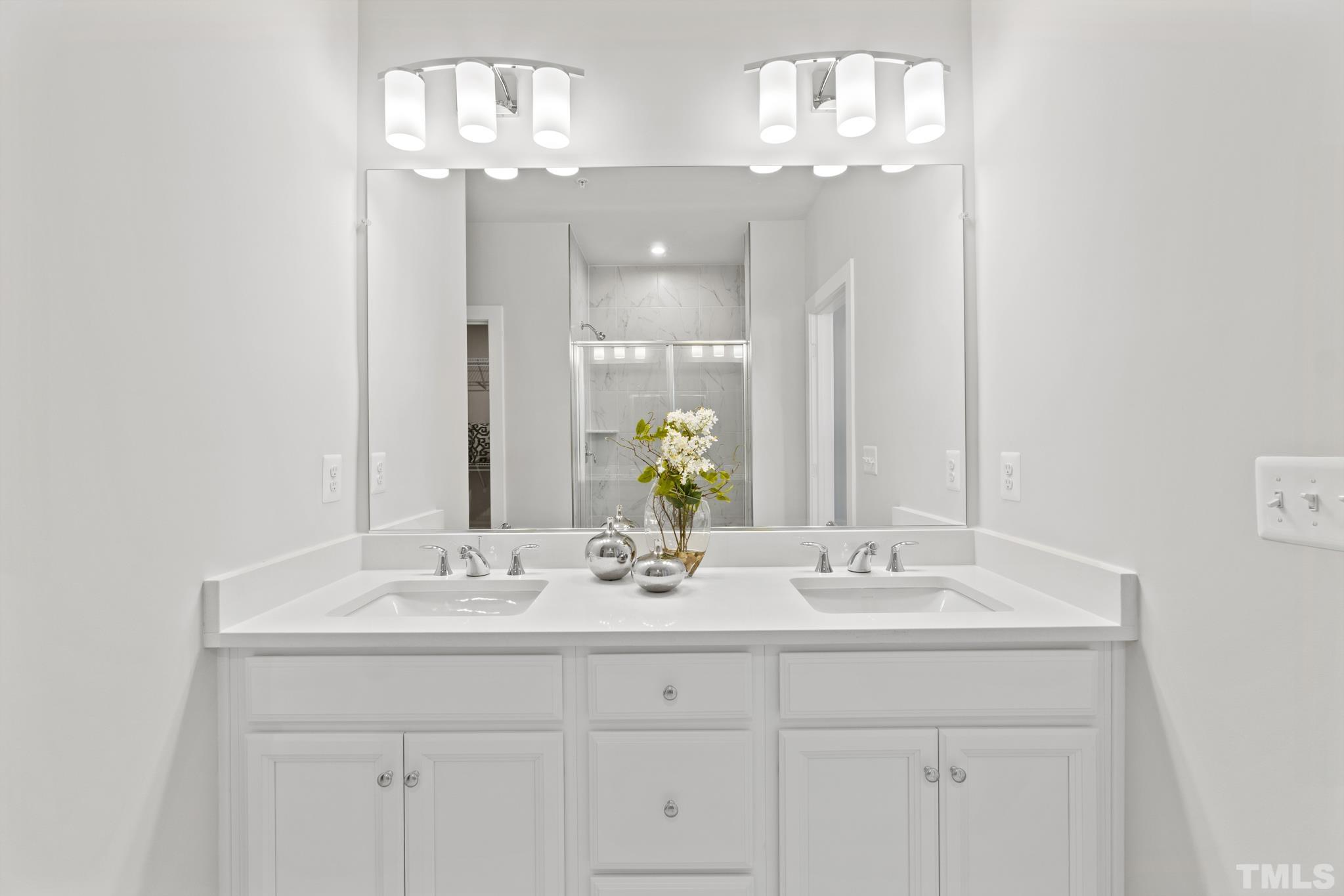 415 Wait Avenue, Unit 100 TESSA Wake Forest, NC 27587 - Photo 13 of 29 a bathroom with a sink double vanity and a mirror