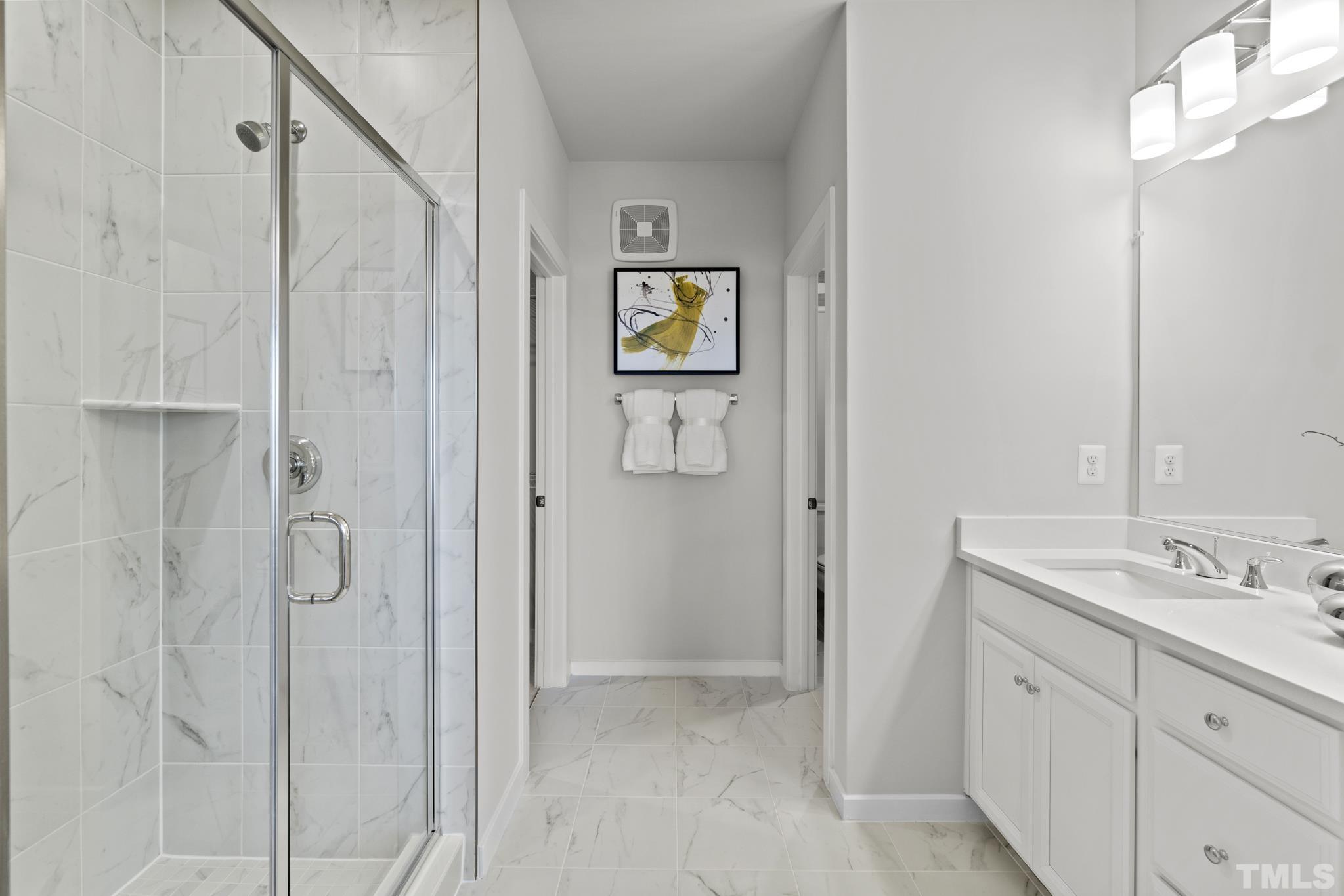 415 Wait Avenue, Unit 100 TESSA Wake Forest, NC 27587 - Photo 15 of 29 a bathroom with a granite countertop sink a mirror and shower