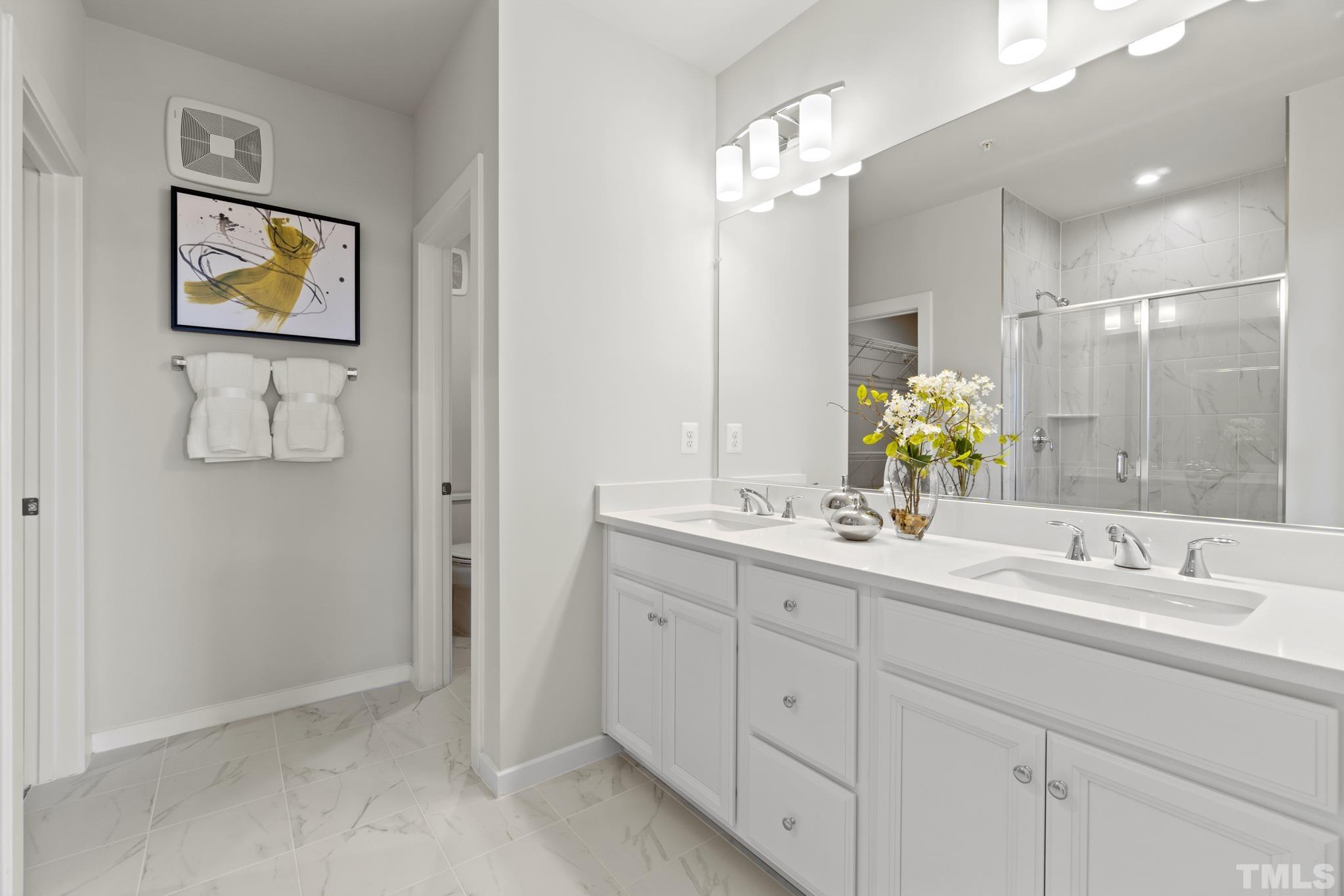 415 Wait Avenue, Unit 100 TESSA Wake Forest, NC 27587 - Photo 16 of 29 a bathroom with a double vanity sink and a mirror