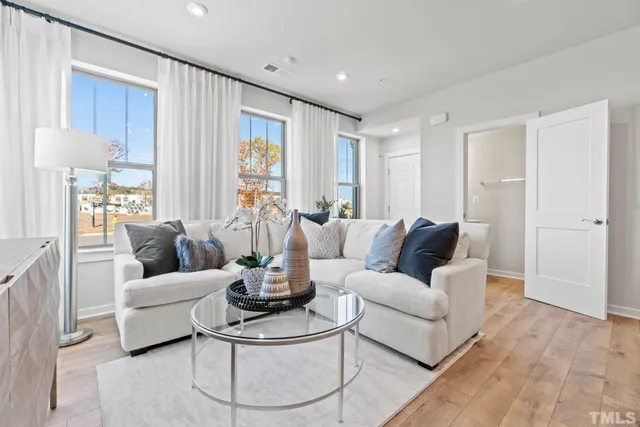 a living room with furniture wooden floor and a large window