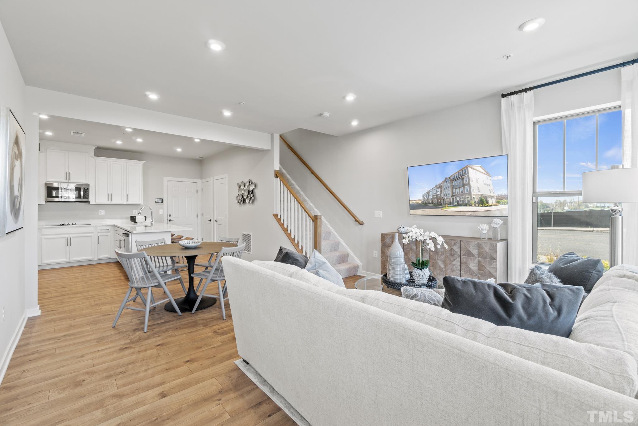 415 Wait Avenue, Unit 100 TESSA Wake Forest, NC 27587 - Photo 8 of 29 a living room with furniture wooden floor and a large window