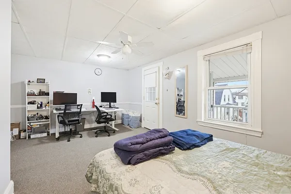 a bedroom with furniture and a large window