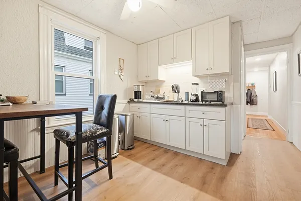 a kitchen with stainless steel appliances kitchen island granite countertop a table chairs sink and cabinets