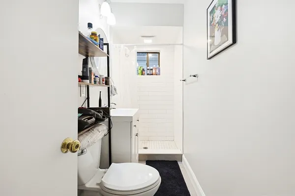 a white toilet sitting next to a bathroom sink and vanity