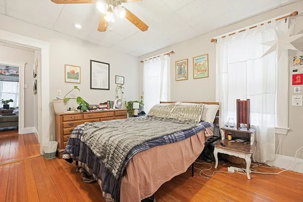 a bedroom with a bed and wooden floor