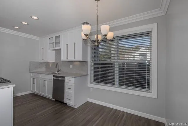 a kitchen with a stove chandelier and wooden floor