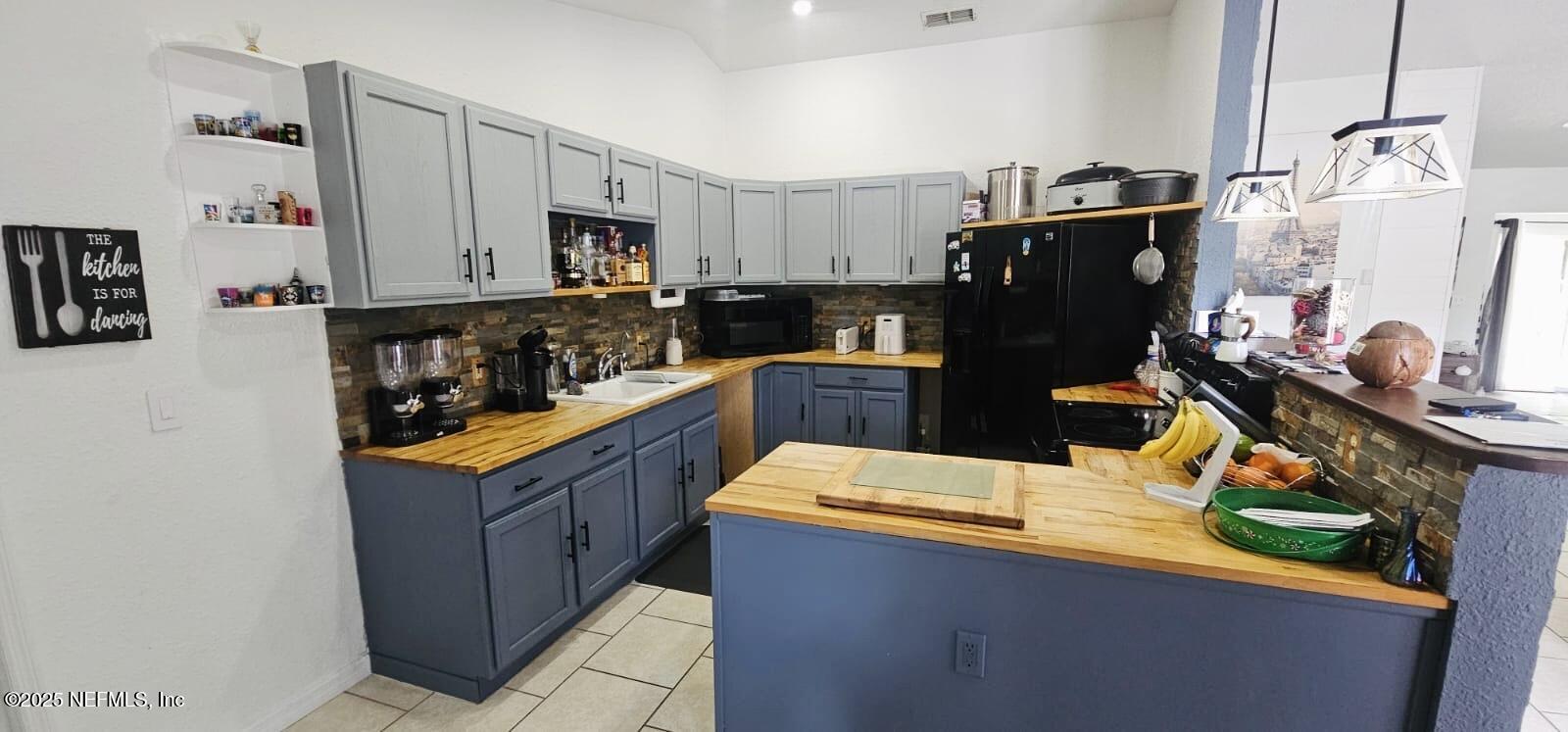 12961 5 Churches Road Sanderson, FL 32087 - Photo 13 of 34 a kitchen with stainless steel appliances granite countertop a sink and a refrigerator