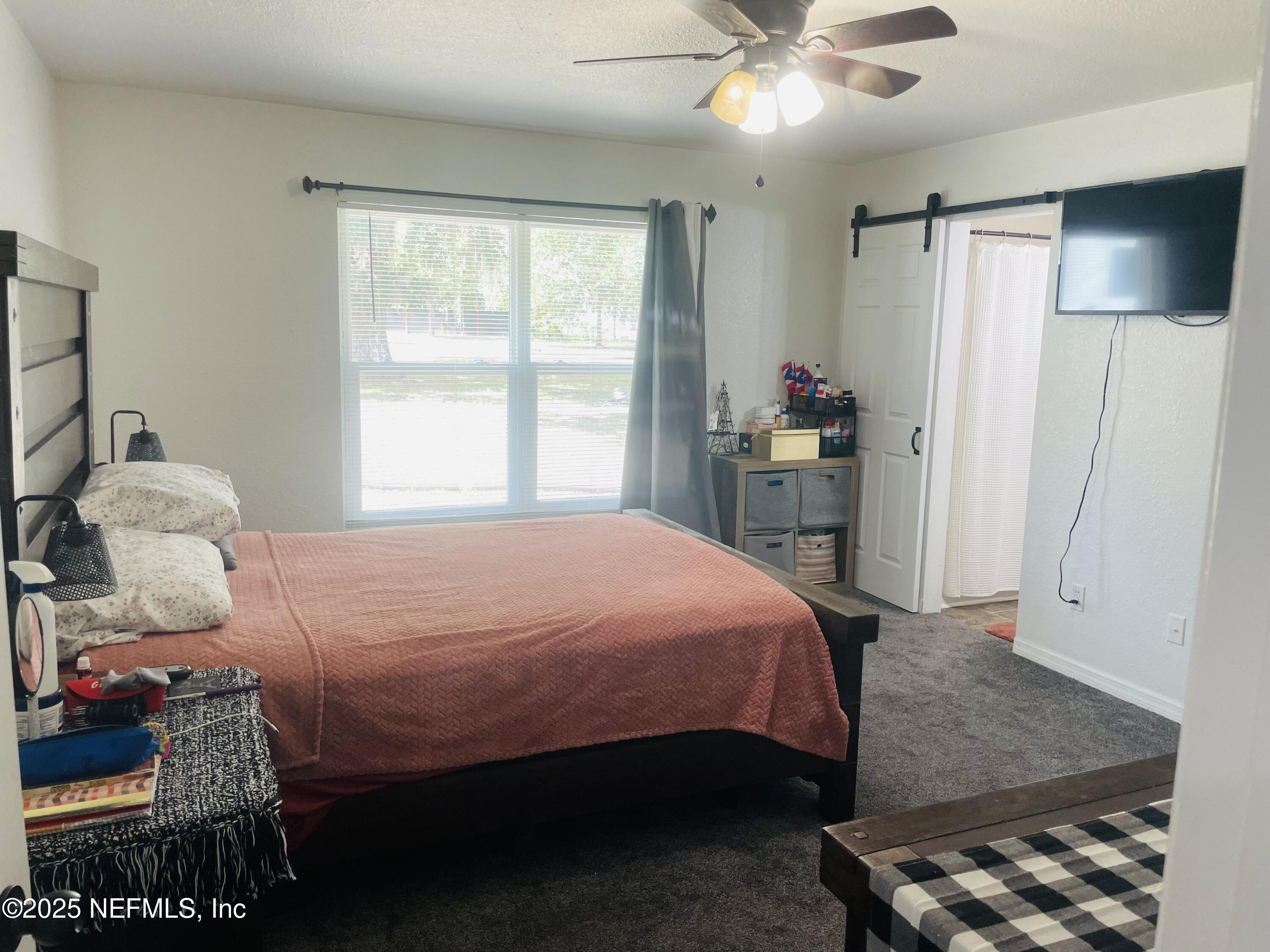 12961 5 Churches Road Sanderson, FL 32087 - Photo 19 of 34 a bedroom with a bed and a chandelier