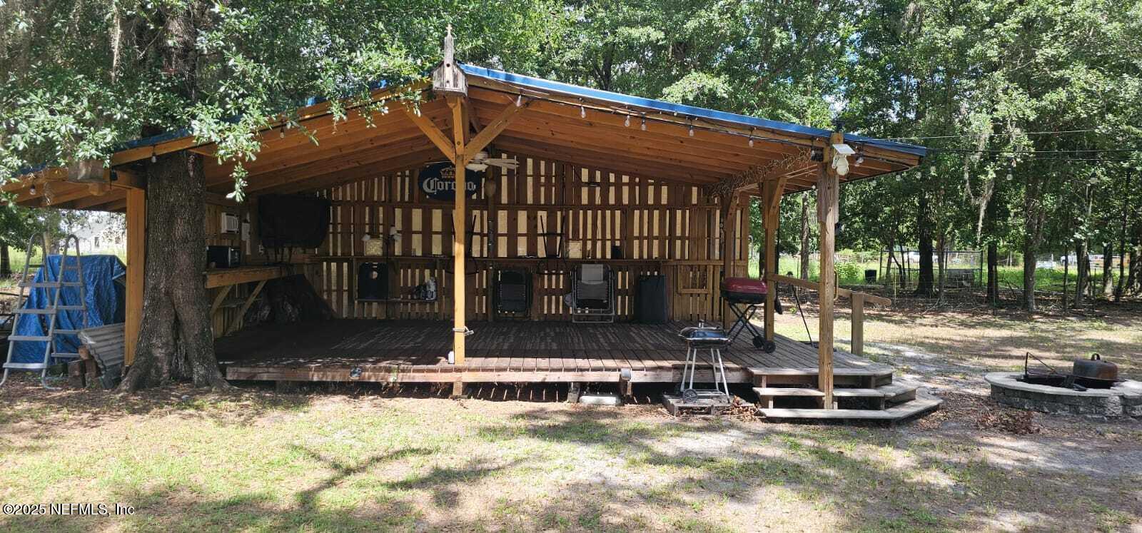 12961 5 Churches Road Sanderson, FL 32087 - Photo 32 of 34 a view of a patio with table and chairs a barbeque with wooden fence