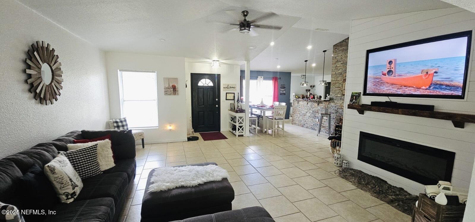 12961 5 Churches Road Sanderson, FL 32087 - Photo 7 of 34 a living room with furniture a flat screen tv and a fireplace