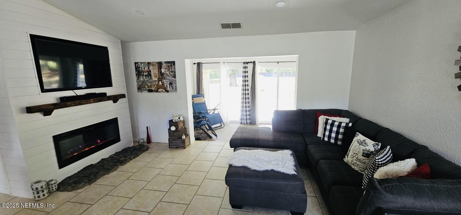12961 5 Churches Road Sanderson, FL 32087 - Photo 9 of 34 a living room with furniture a flat screen tv and a fireplace