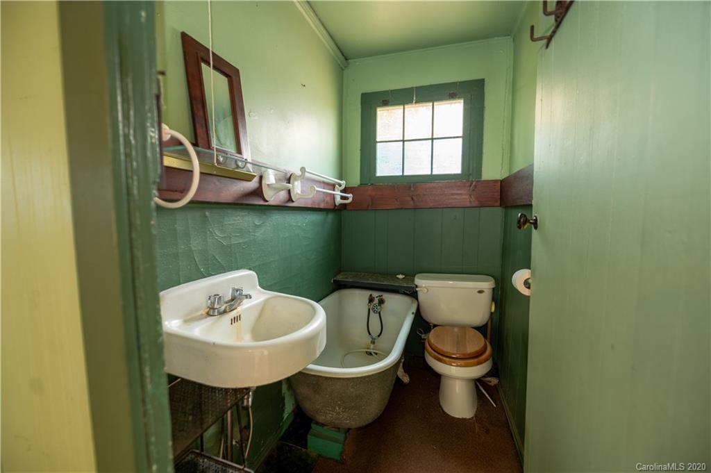 150 Oak Hill Road Candler, NC 28715 - Photo 5 of 25 a bathroom with a toilet sink and mirror
