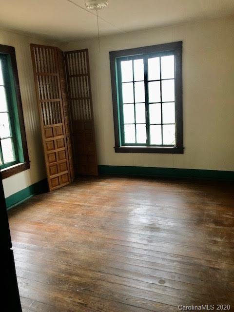 150 Oak Hill Road Candler, NC 28715 - Photo 7 of 25 an empty room with wooden floor and windows