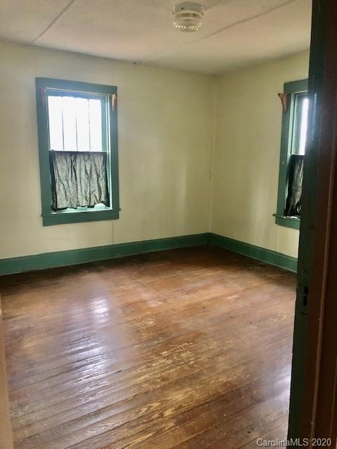 150 Oak Hill Road Candler, NC 28715 - Photo 8 of 25 an empty room with wooden floor and windows