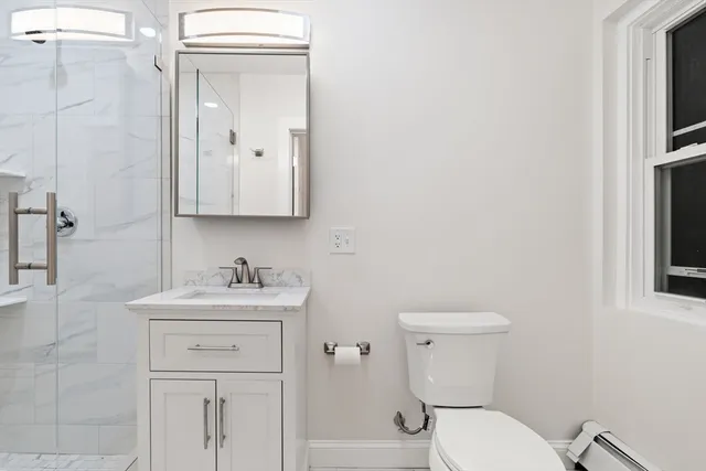 a bathroom with a toilet sink vanity and mirror