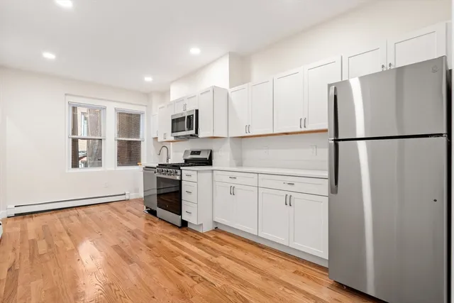 a kitchen with white cabinets and stainless steel appliances