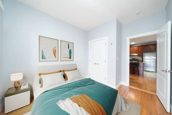 a bedroom with a bed and wooden floor