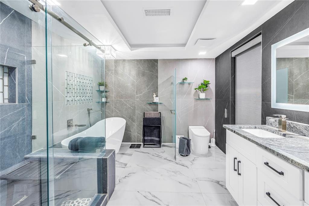 583 Crystal Drive Madeira Beach, FL 33708 - Photo 11 of 100 a spacious bathroom with a granite countertop sink a toilet and shower