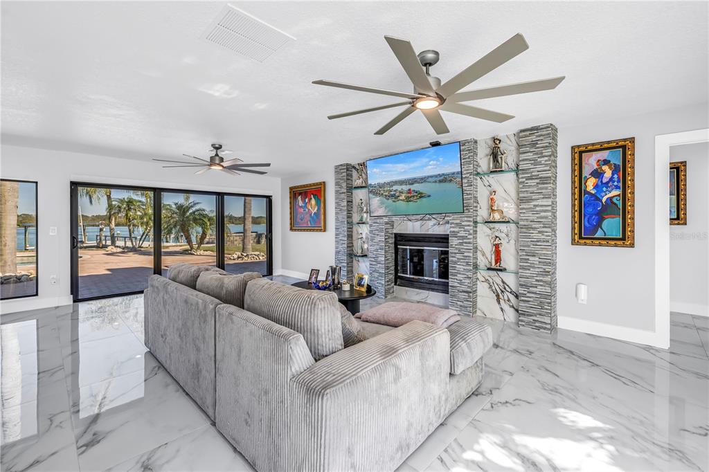 583 Crystal Drive Madeira Beach, FL 33708 - Photo 13 of 100 a living room with furniture a ceiling fan and a fireplace