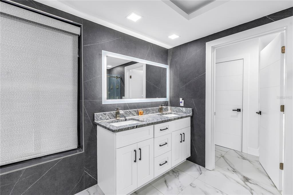 583 Crystal Drive Madeira Beach, FL 33708 - Photo 38 of 100 a bathroom with a double vanity sink and mirror