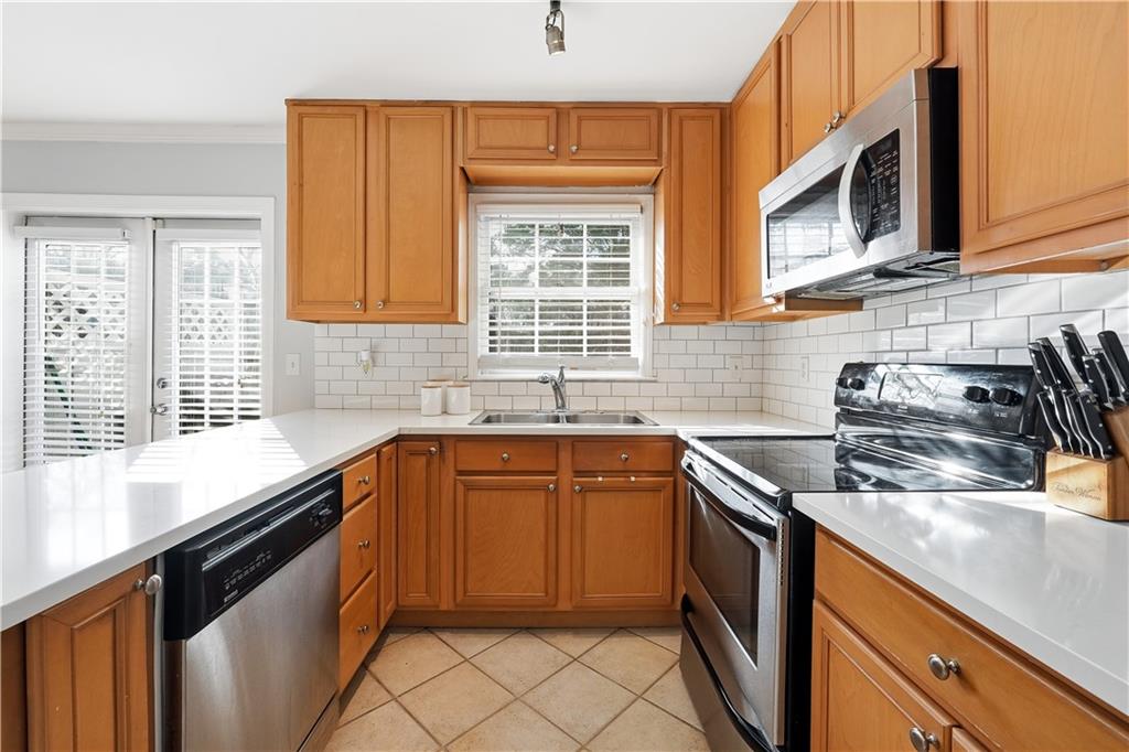 1101 Collier Road Northwest, Unit Q6 Atlanta, GA 30318 - Photo 4 of 20 a kitchen with stainless steel appliances granite countertop a sink stove and cabinets