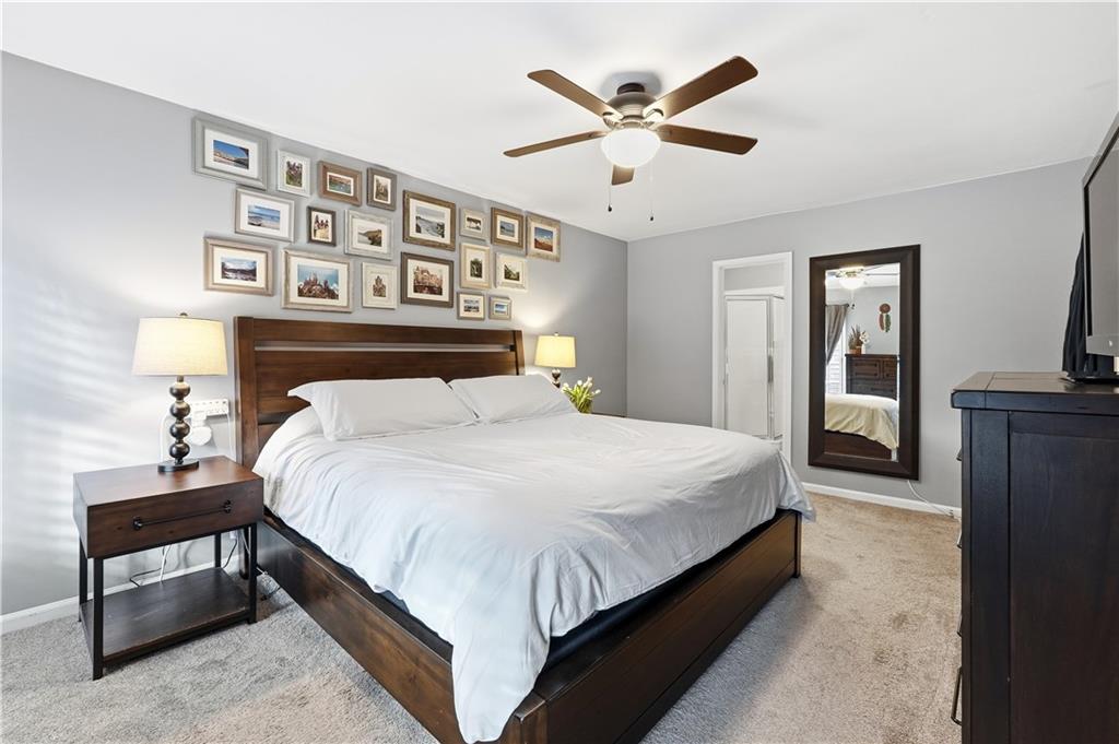 1101 Collier Road Northwest, Unit Q6 Atlanta, GA 30318 - Photo 10 of 20 a bedroom with a large bed and a chandelier