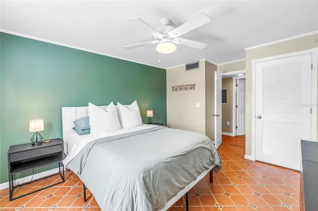 a spacious bedroom with a bed and a chandelier