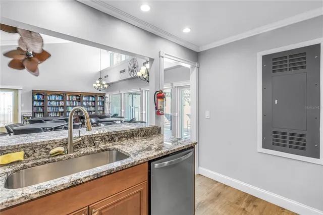 a kitchen with granite countertop a sink a counter top space and cabinets