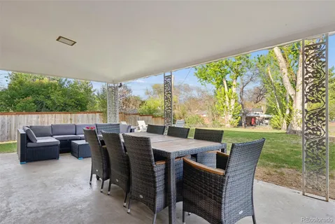 a view of a chair and table in backyard of the house