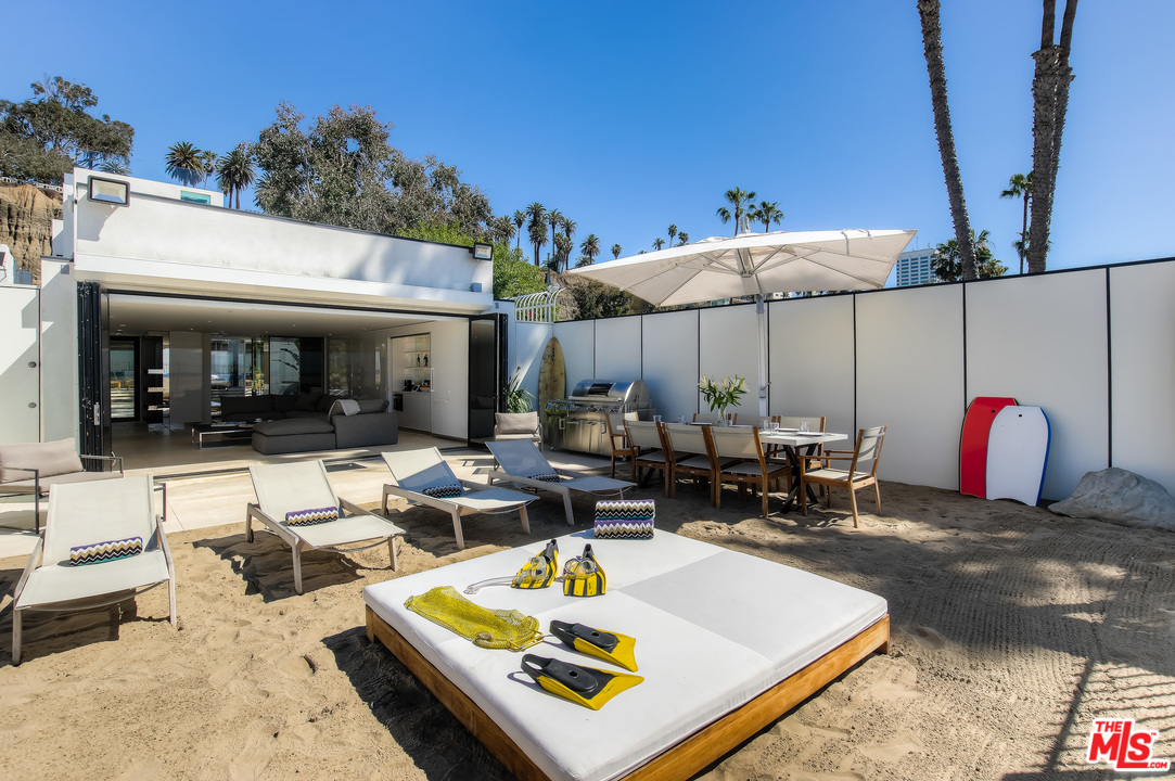 924 Palisades Beach Road Santa Monica, CA 90403 - Photo 38 of 54 a view of a patio with a table and chairs under an umbrella