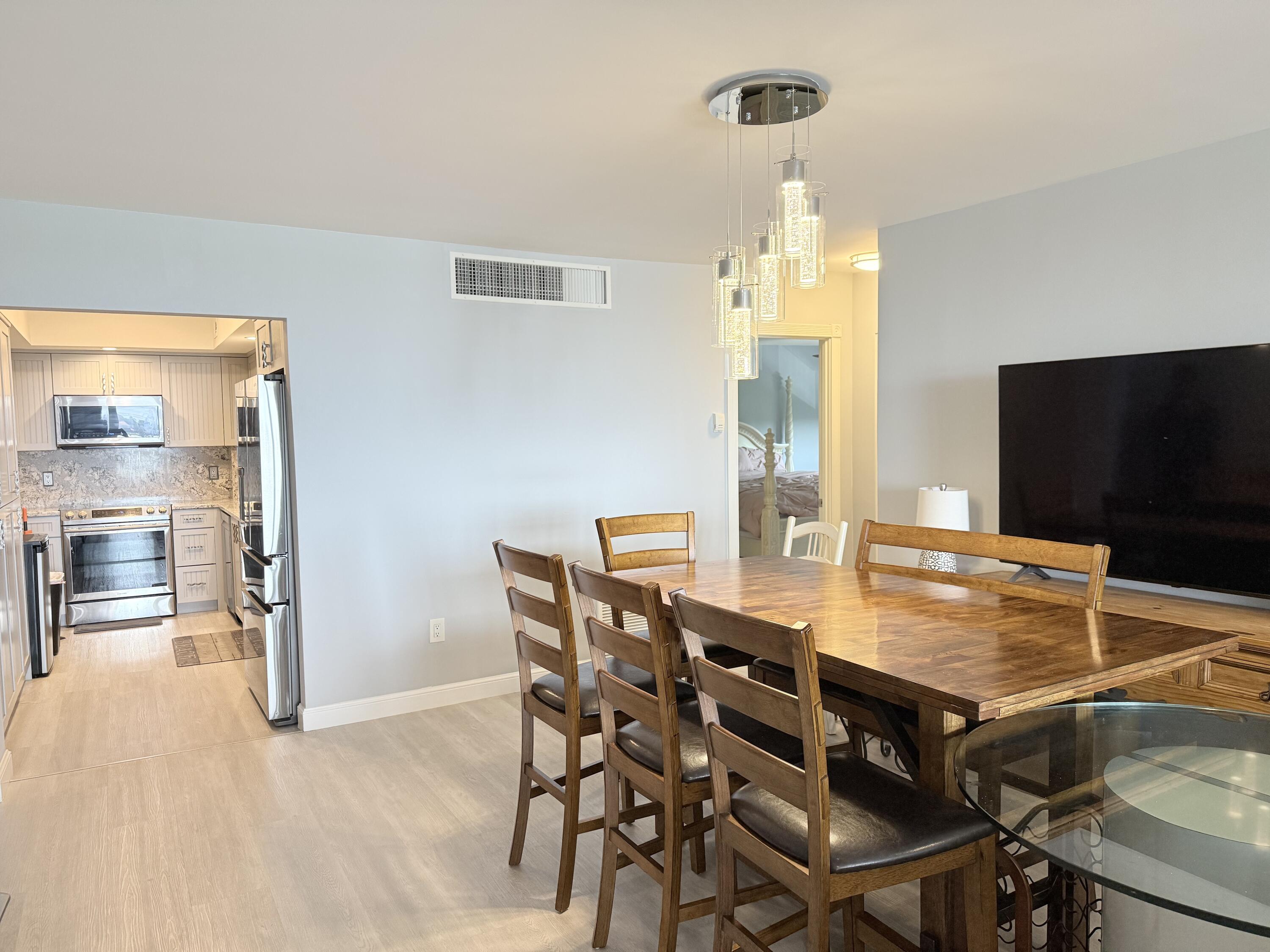 3450 South Ocean Boulevard, Unit 2220 Palm Beach, FL 33480 - Photo 7 of 36 a view of a dining room with furniture and a flat screen tv