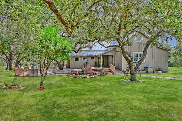 a front view of a house with garden and trees