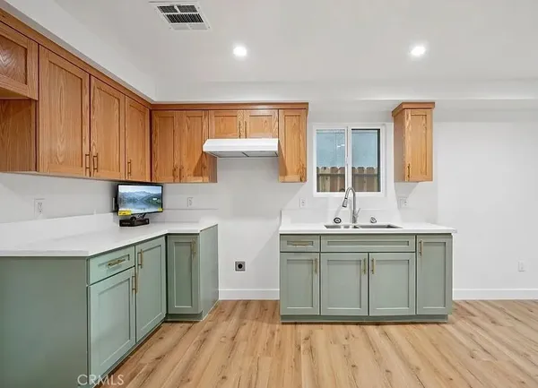 a kitchen with a sink cabinets and wooden floor