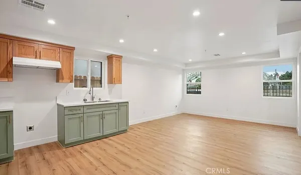 a kitchen with stainless steel appliances granite countertop a sink and cabinets with wooden floor