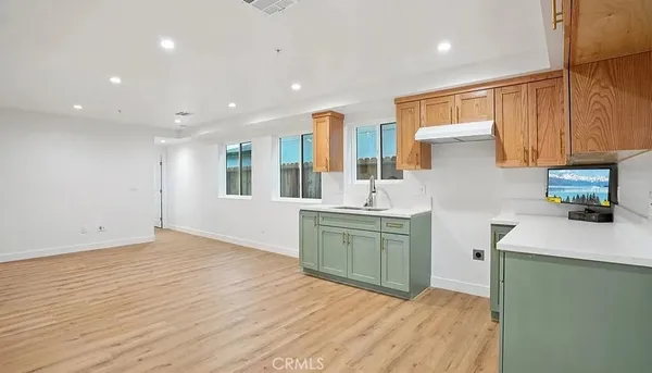 a kitchen with a sink cabinets and wooden floor