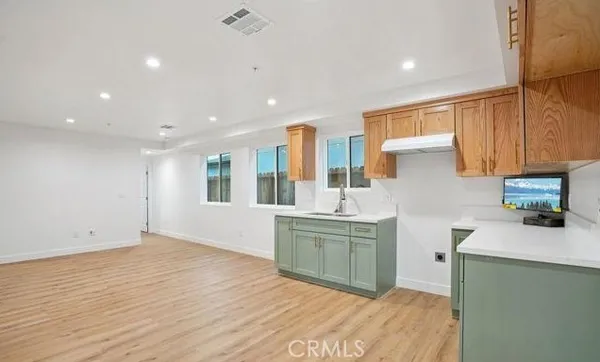 a kitchen with a sink dishwasher a stove and a refrigerator with wooden floor