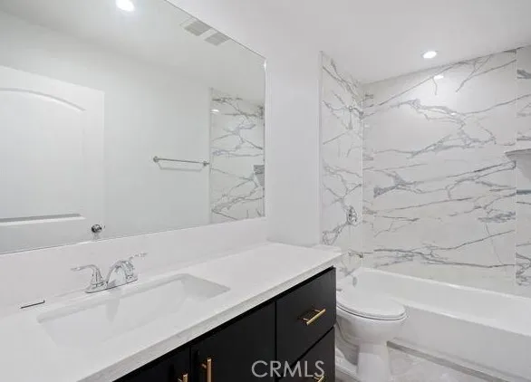 a bathroom with a sink toilet vanity and shower