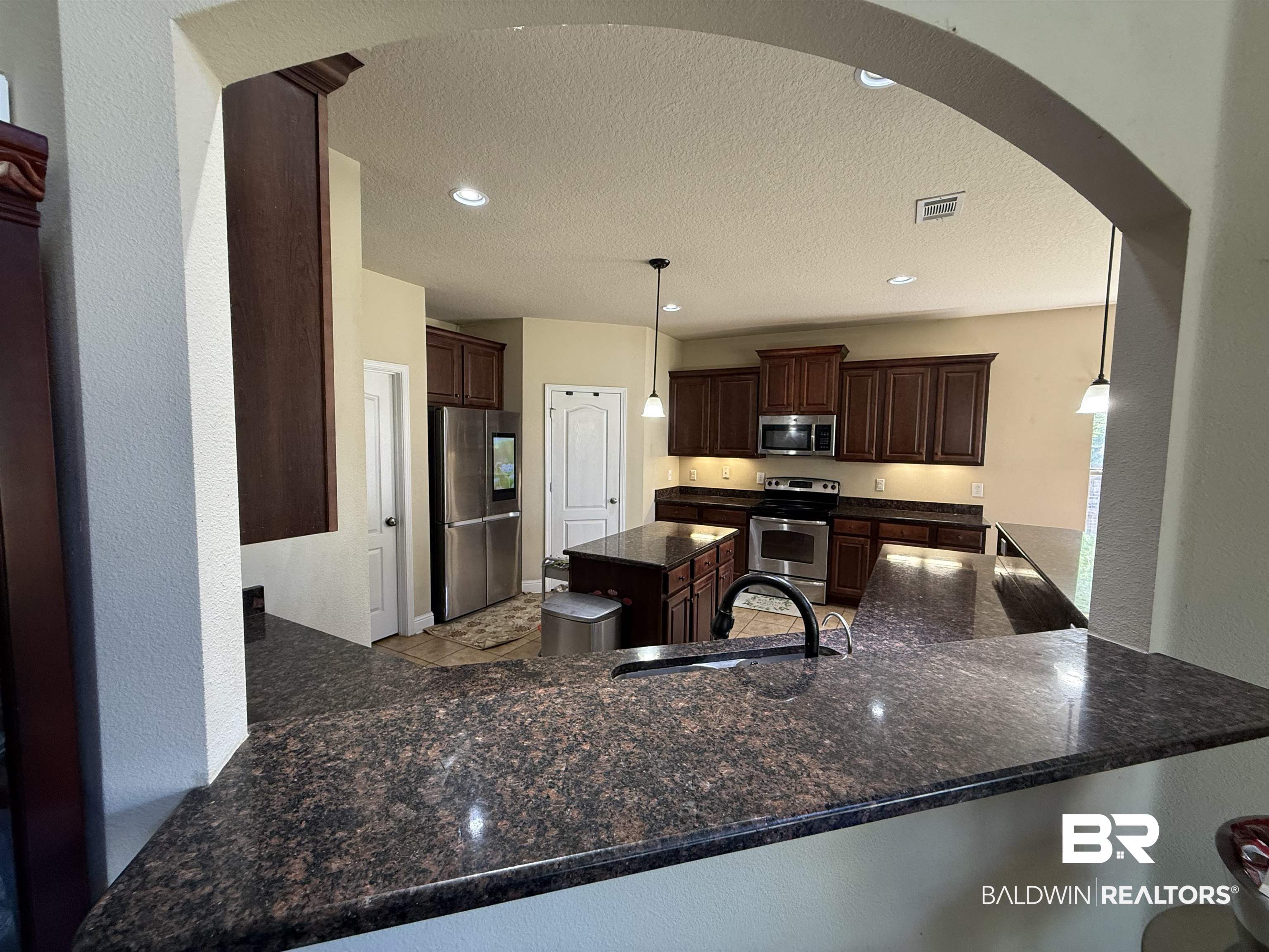 9023 Krystal Ridge Court Daphne, AL 36526 - Photo 14 of 41 Kitchen with a kitchen island, recessed lighting, stainless steel appliances, decorative light fixtures, and dark brown cabinetry