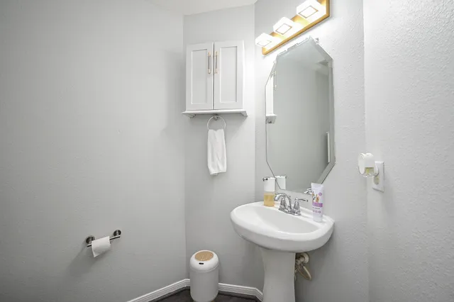 a bathroom with a sink a toilet and a mirror