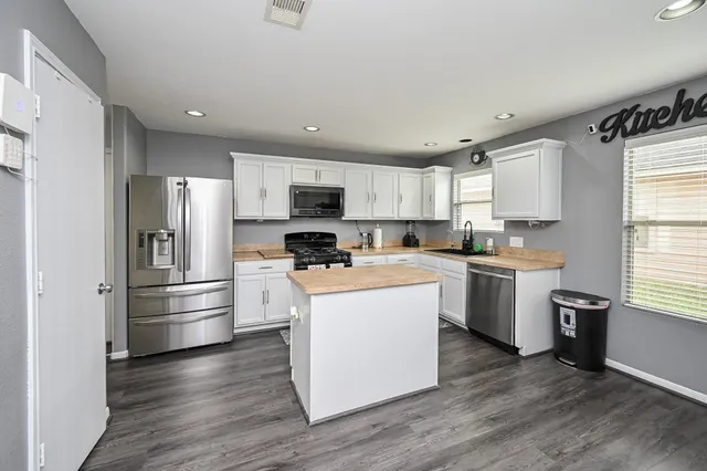 a kitchen with a refrigerator stove and wooden cabinets