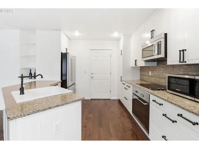 a kitchen with stainless steel appliances granite countertop a sink stove and refrigerator