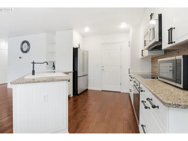 a kitchen with granite countertop a sink stove and refrigerator