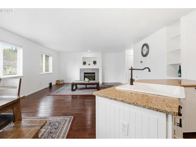 a kitchen with granite countertop a sink and a stove top oven with wooden floor