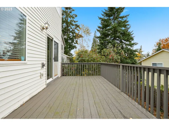 a balcony with wooden floor in front of house